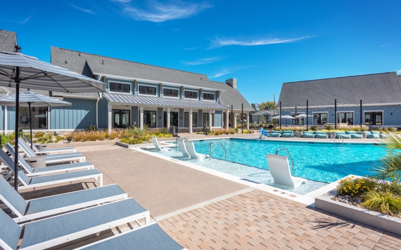 a swimming pool with lounge chairs in a courtyard
