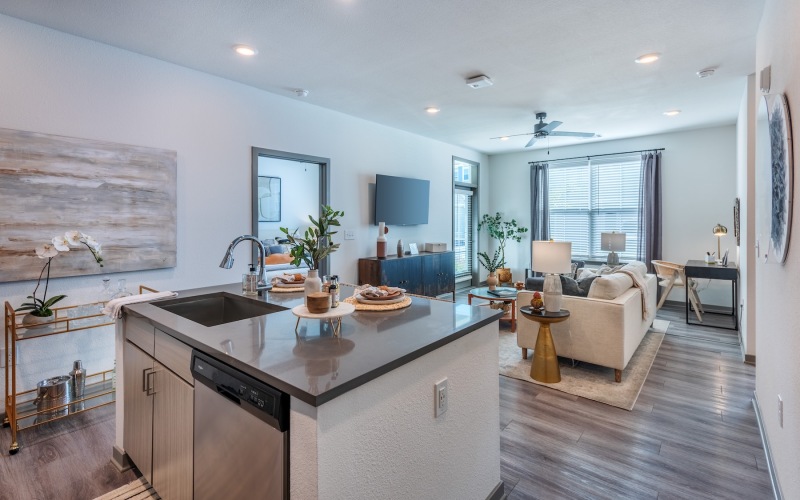 a kitchen island and a living room with a couch and a tv